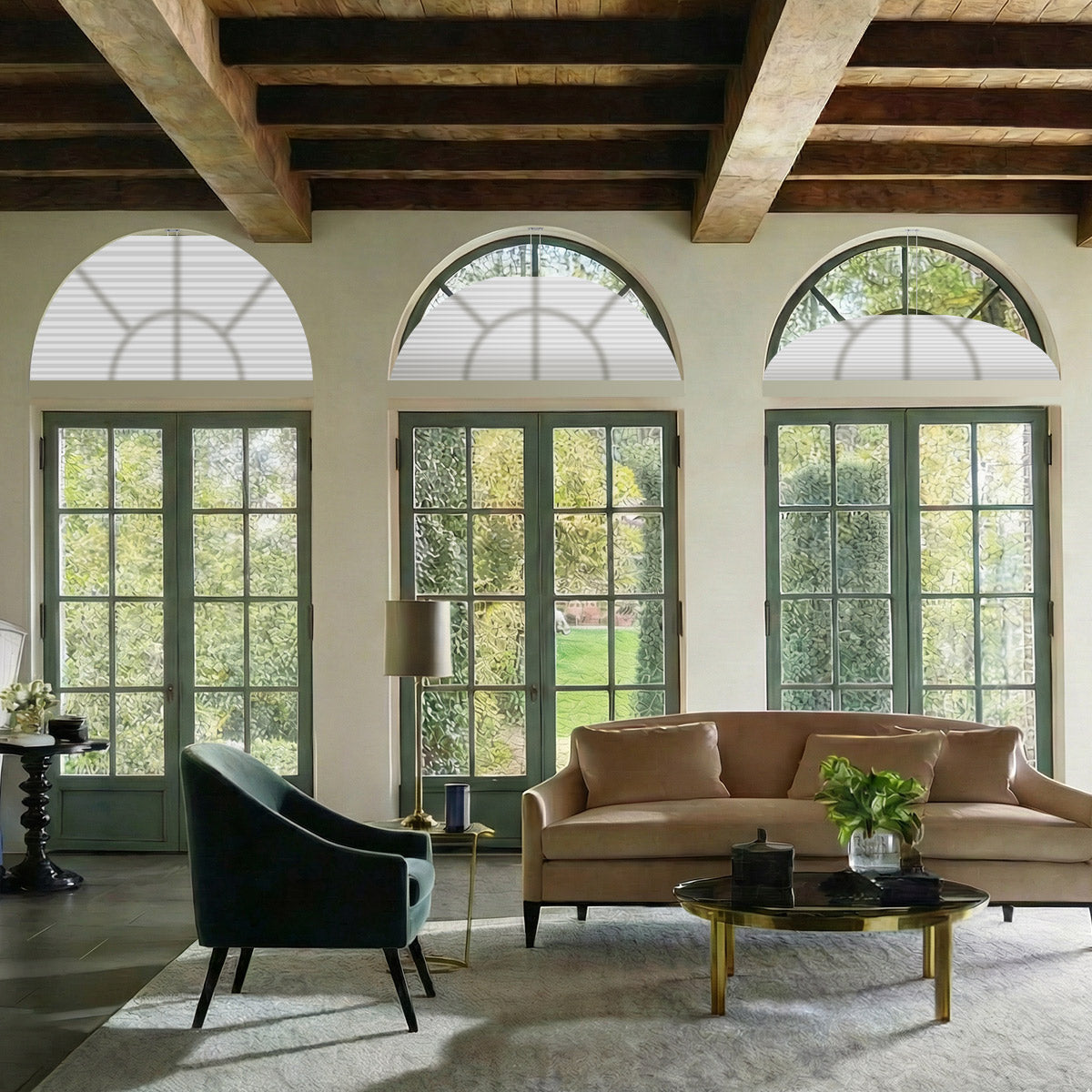 Three white arched cellular shades over green-framed French doors in a living room with exposed wood beams