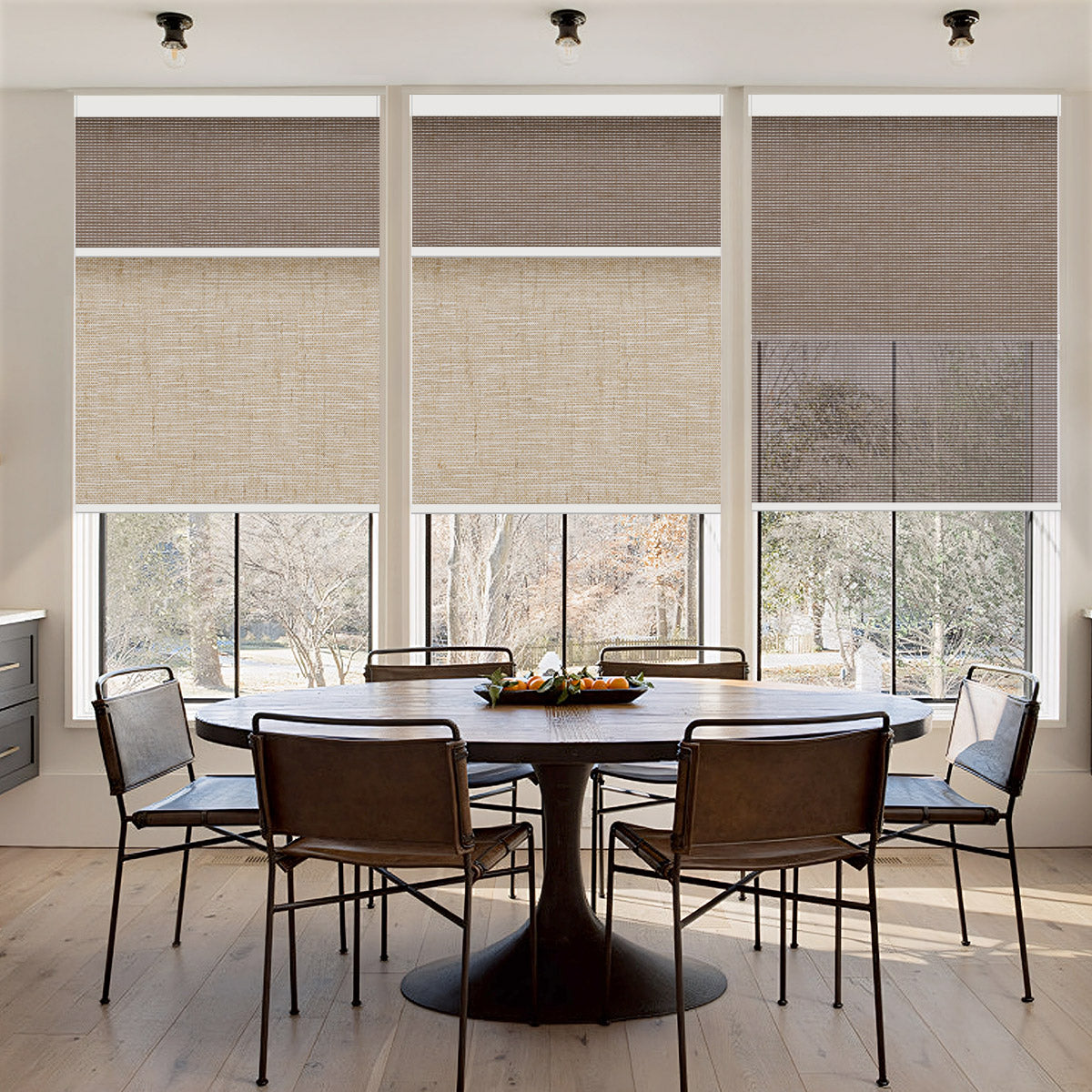Dining room with a row of windows dressed in motorized dual shades in a linen-look fabric, partly lowered over the garden view