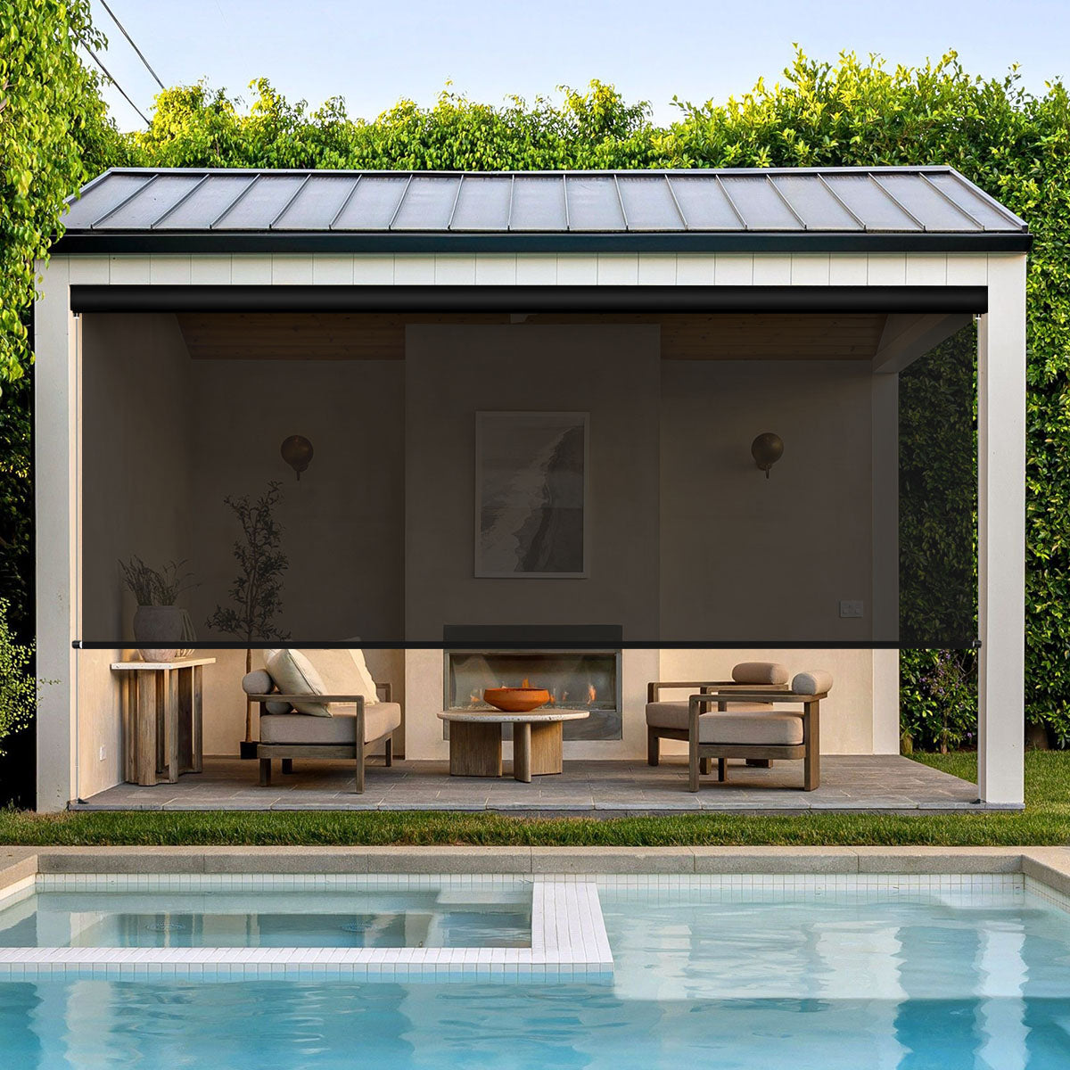Dark grey motorized outdoor shades lowered around a poolside pavilion with lounge seating