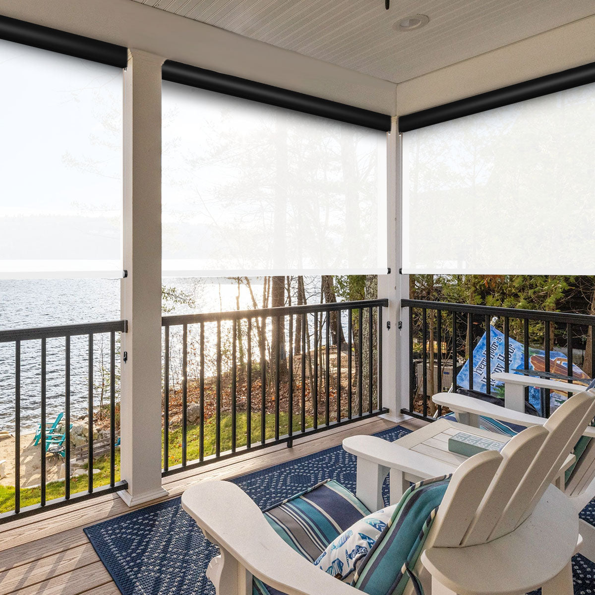 Covered lakeside porch with white motorized outdoor shades lowered as a windbreak behind Adirondack chairs