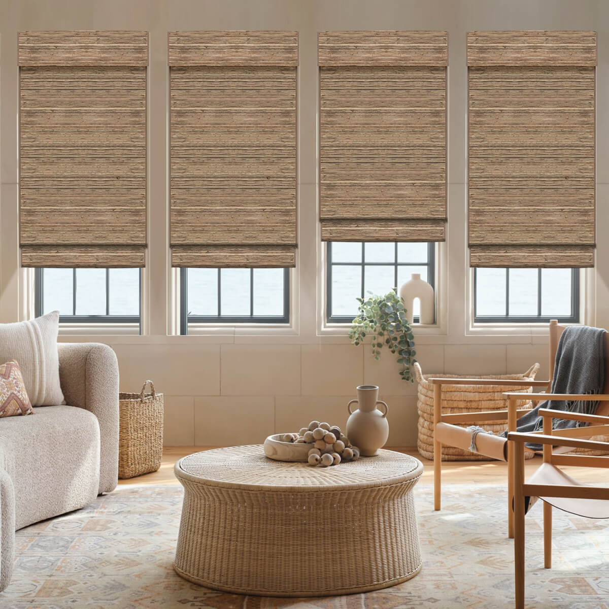 Chestnut bamboo woven wood shades on four windows in a living room with a round rattan coffee table