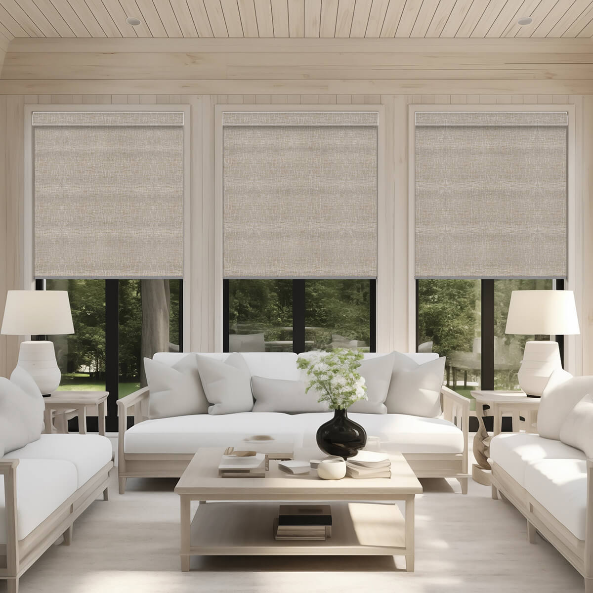 Biscuit textured motorized roller shades on three living room windows overlooking trees