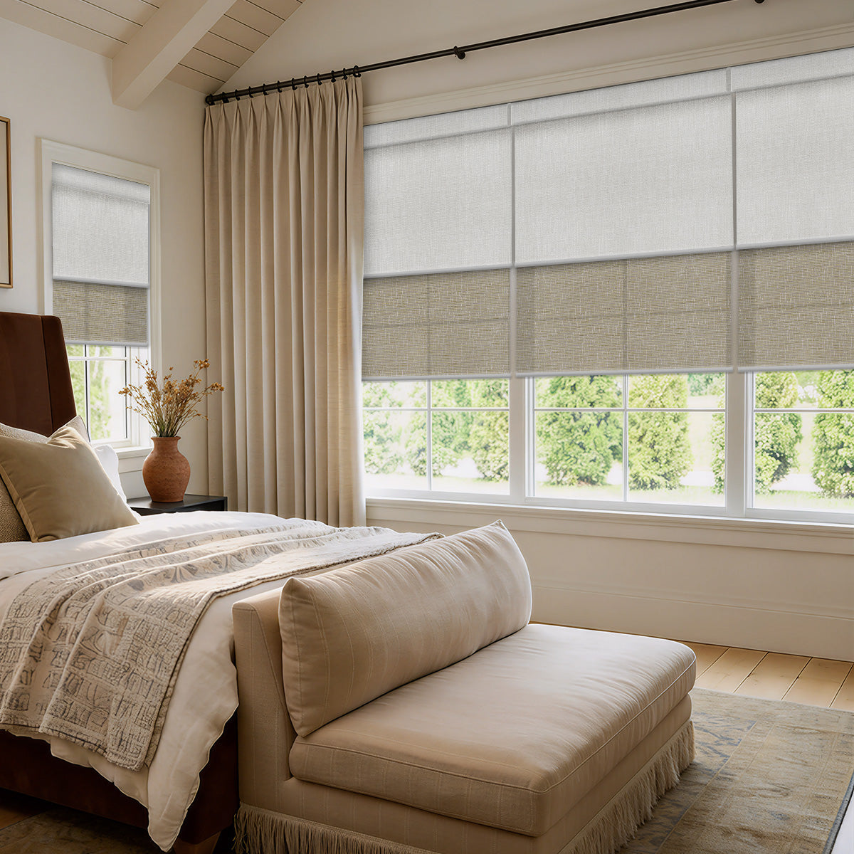Bedroom with an upholstered bench, linen curtains and motorized dual shades partly lowered over a wide window