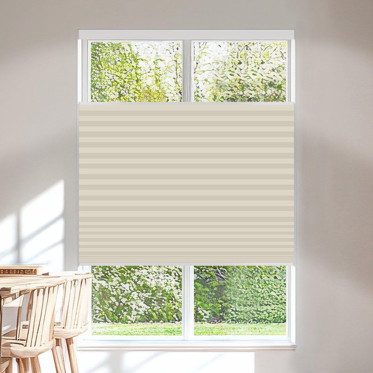 Cream blackout top down bottom up cellular shade lowered from the top for daylight while the lower window stays covered