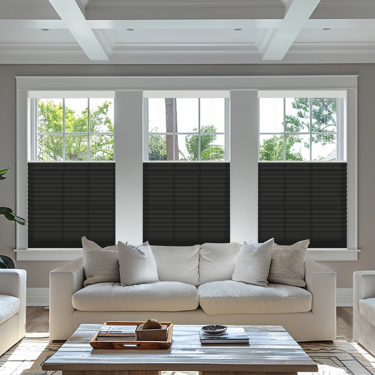Dark grey light filtering top down bottom up cellular shades lowered from the top on three living room windows