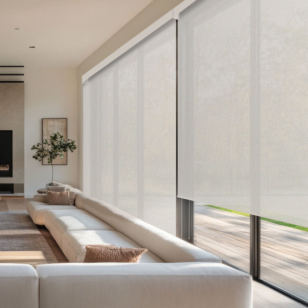 Light filtering solar roller shades over floor-to-ceiling glass doors in a bright living room