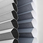 Close-up of a striped fabric blind showcasing elegant gray and blue patterns in soft light.