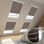 Cozy bedroom with skylights covered by blinds, showcasing a comfortable bed adorned with soft pillows.