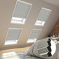 Cozy bedroom with skylights covered by blinds, showcasing a comfortable bed adorned with soft pillows.